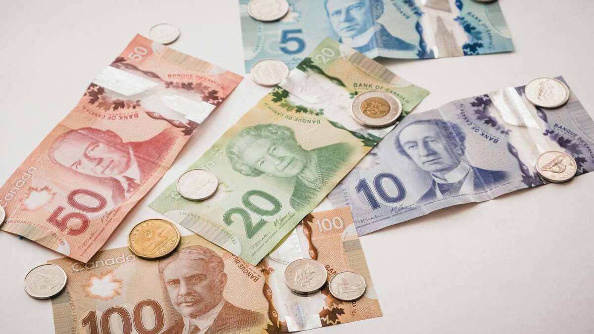 Canadian paper currency and coins spread across a desk