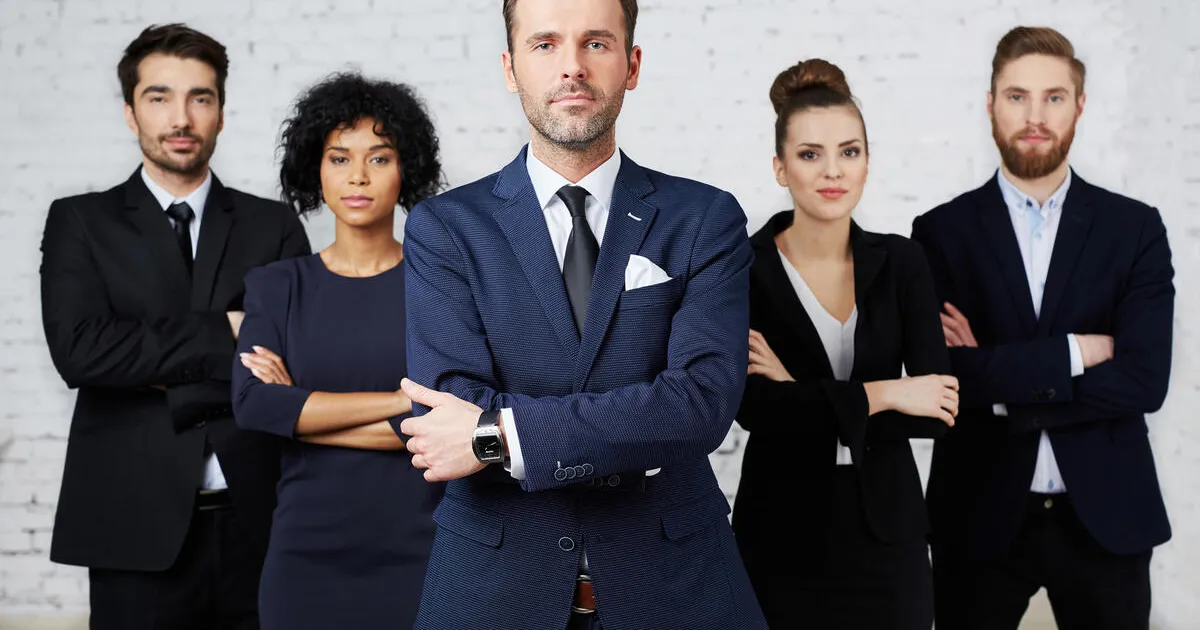 A group of five young lawyers, three male and two female, dressed in business attire with serious looks on their faces