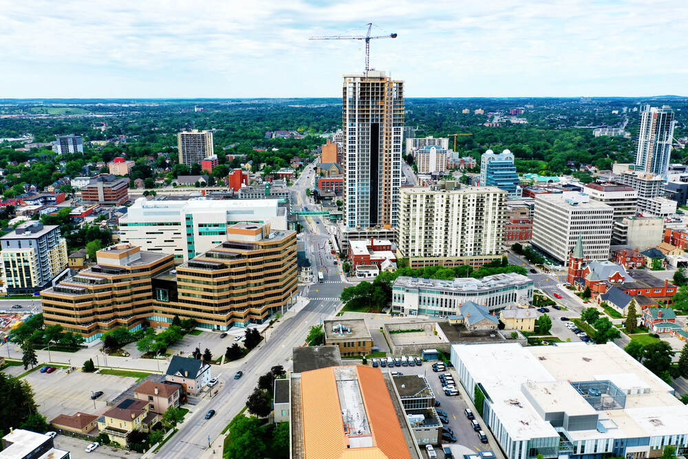 An aerial view of downtown Kitchener, Ontario, centered around the intersection of Frederick Street and Weber Street. The Waterloo Region Courthouse features prominently.
