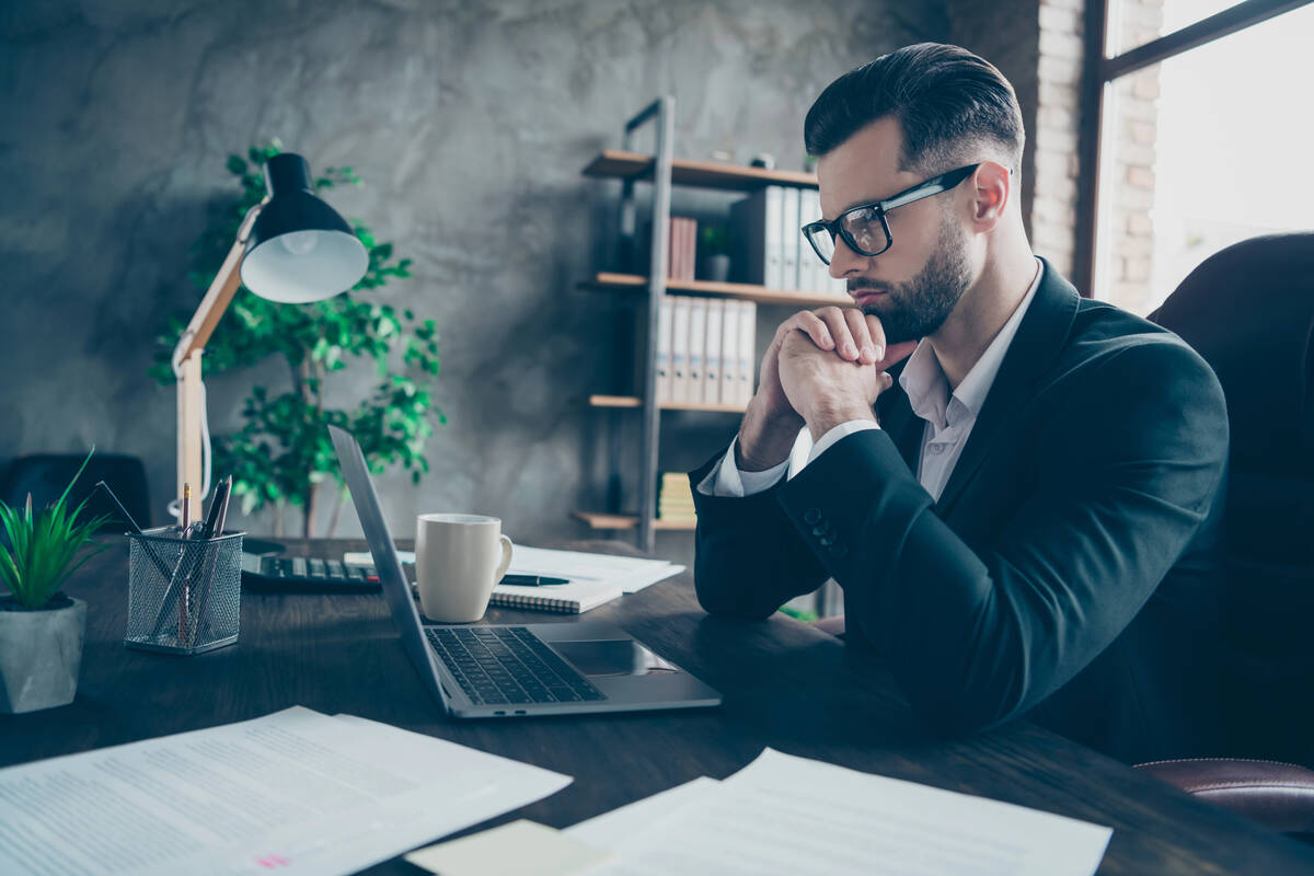Profile photo of focused lawyer looking at his notebook on a table reading marketing reports
