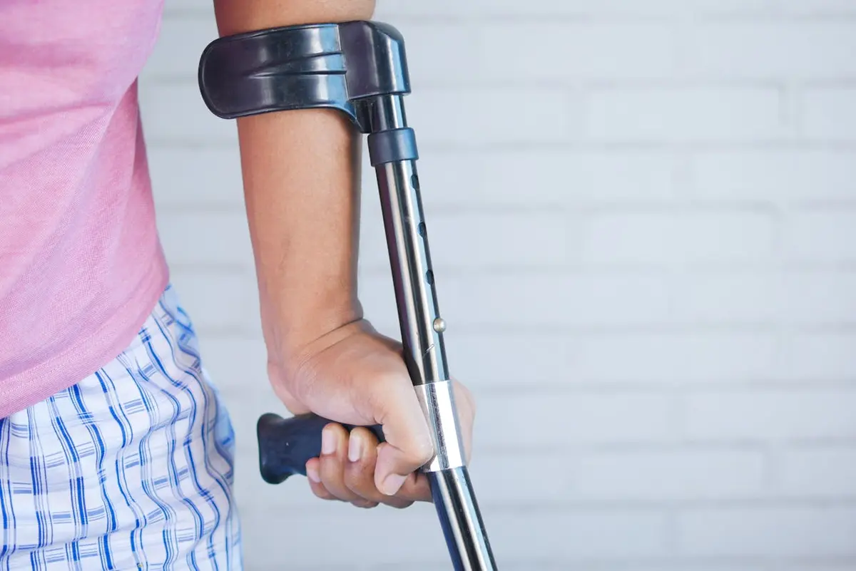 An injured person leans on a crutch for support