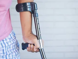 An injured person leans on a crutch for support