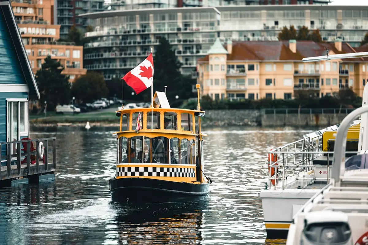 A Canadian flag waves proudly from a water taxi cruising through Victoria Harbour in British Columbia