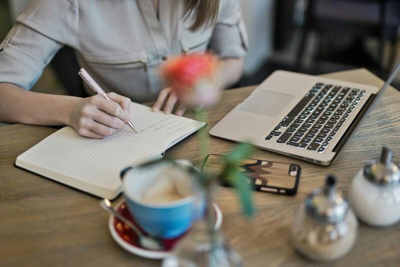 Writer at desk, natural light, notebook